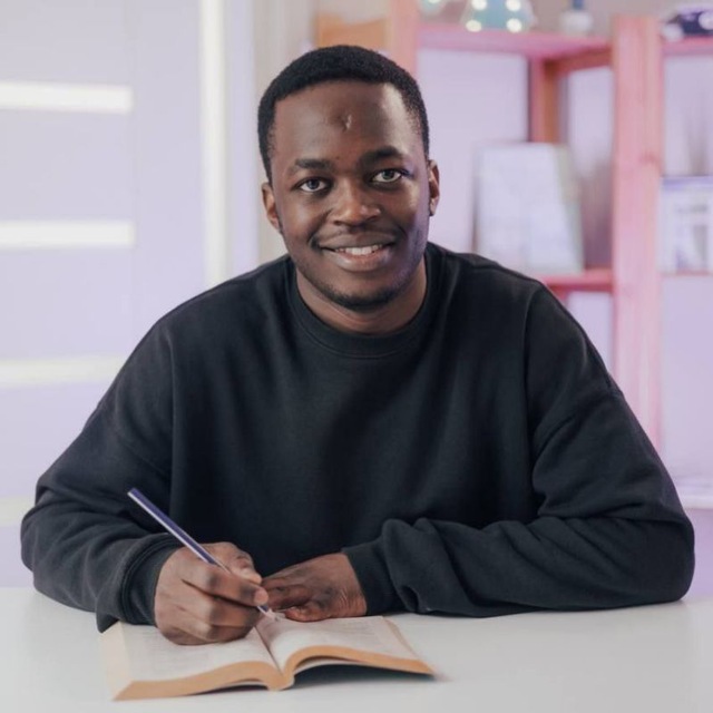 Tafadzwa Takawira smiling, writing in a notebook